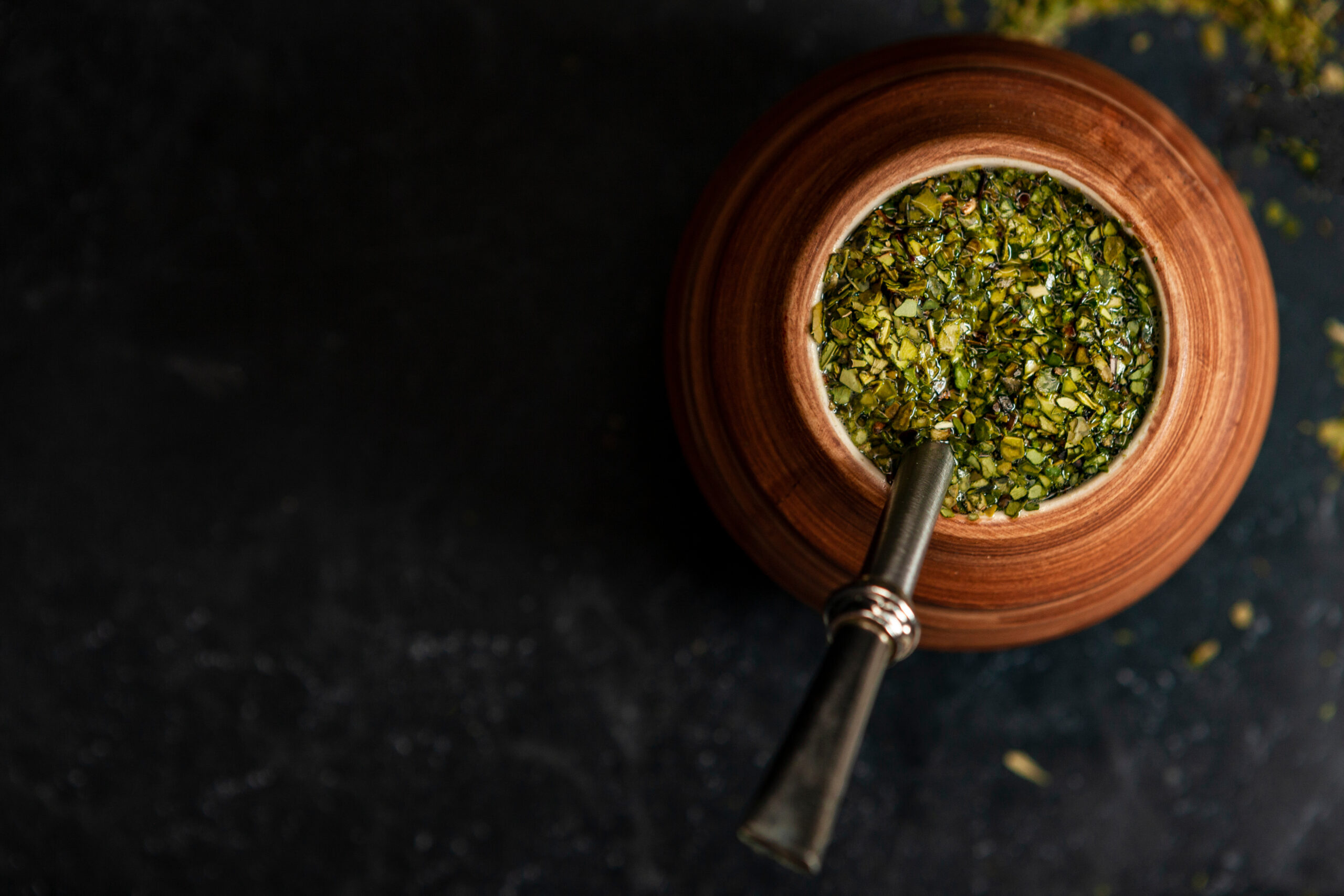 composition of yerba mate on a black background - Juicy and green leaves without sticks